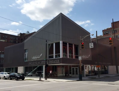 The Otto M. Budig Theater from across the corner showing the entrance, peaked room, bay window, and curtain-like walls of the exterior. 